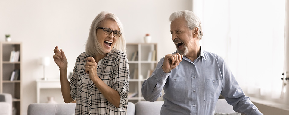 Um casal de idosos dança alegremente no quarto